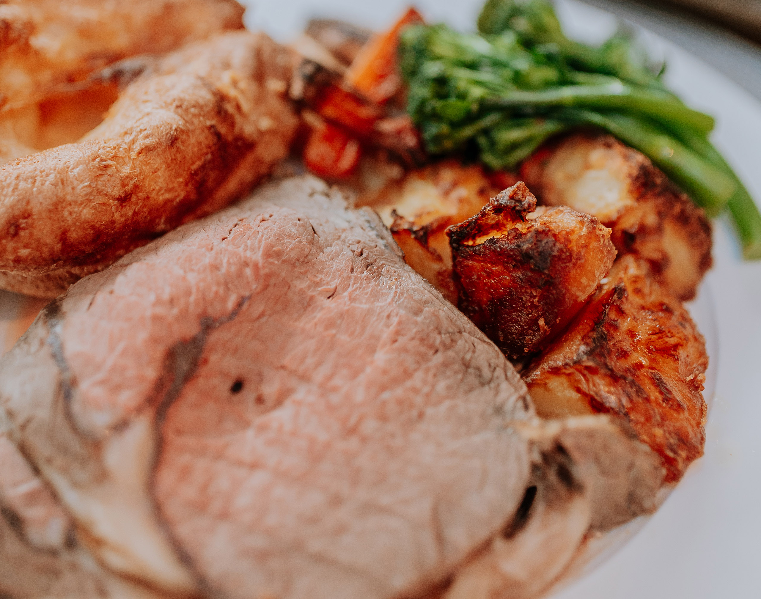 Close up photo of roast meat and potatoes, as part of a traditional Sunday roast dinner