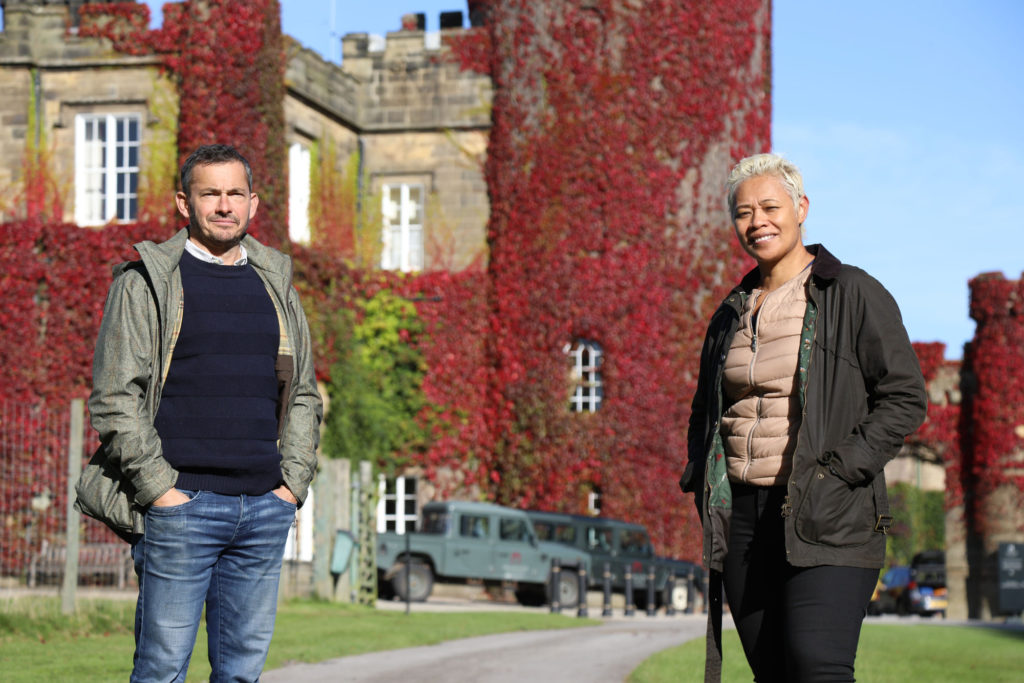 Monica Galetti and Giles Coren from the Amazing Hotels TV series stand in front of Swinton Park hotel on the Swinton Estate in North Yorkshire