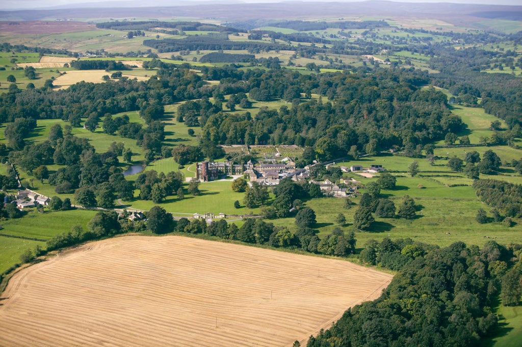 An aerial photograph of Swinton Estate in Yorkshire featuring countryside, fields, trees and Swinton Park luxury spa hotel