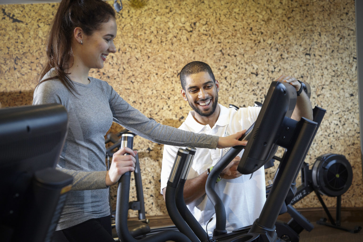 A personal trainer guiding someone on gym equipment at Swinton Country Club near Masham and Ripon