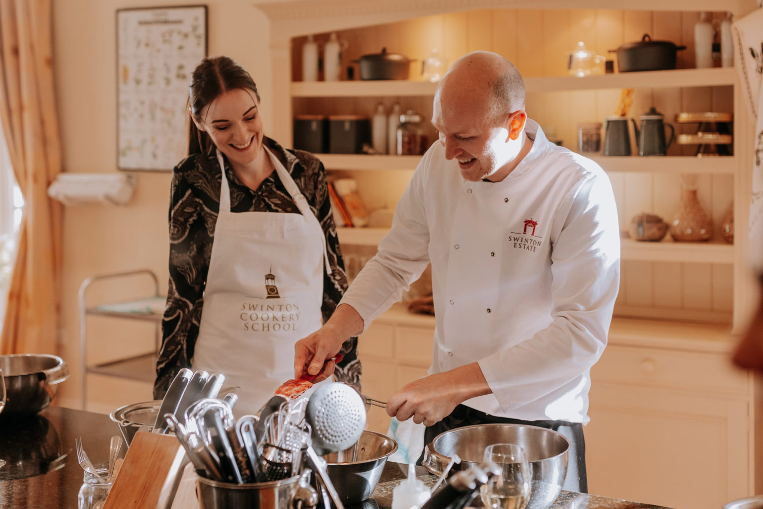 Chef teaching a student during a cookery course at Swinton Cookery School near Harrogate in Yorkshire