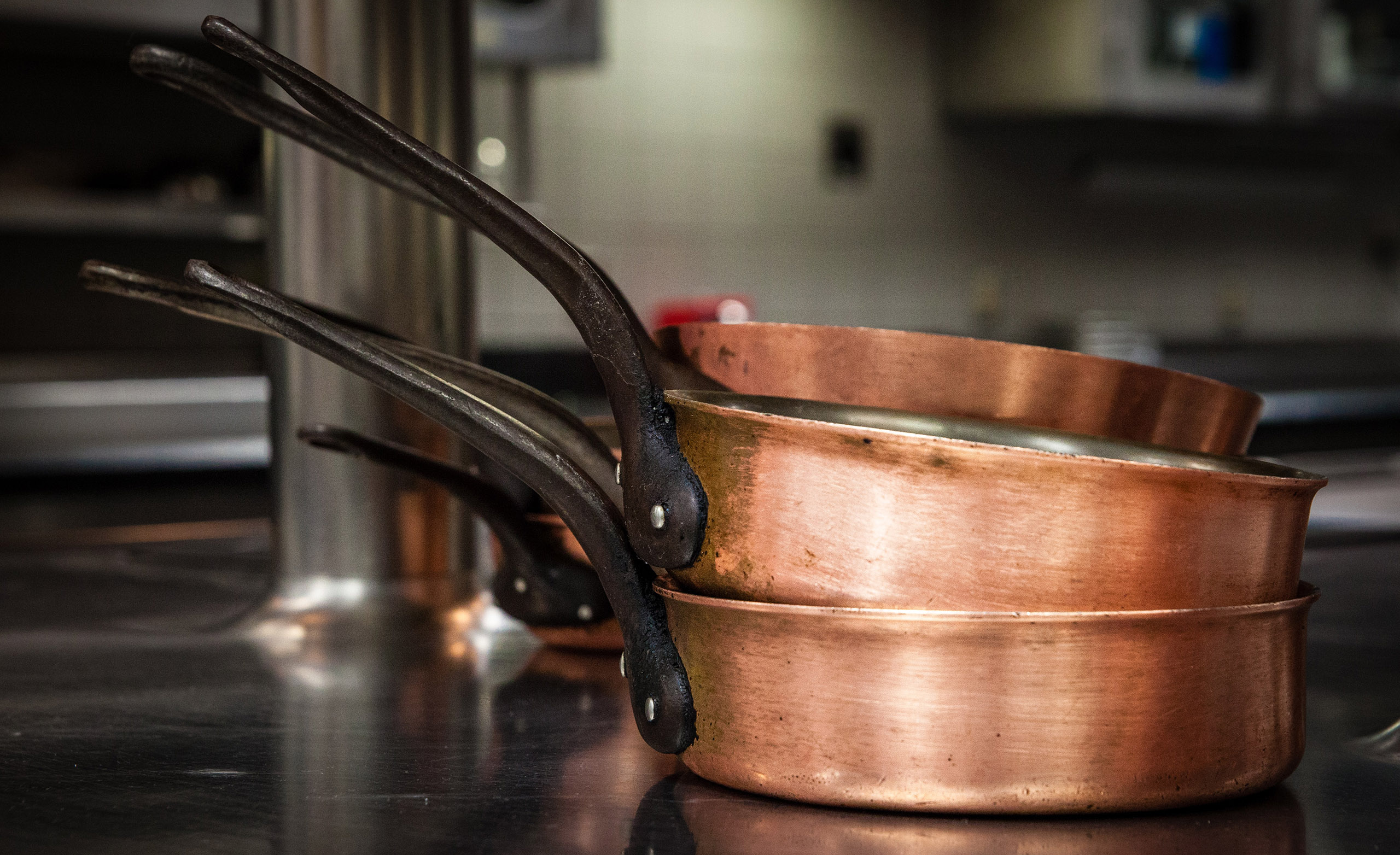 Three copper frying pans stacked on top of each other