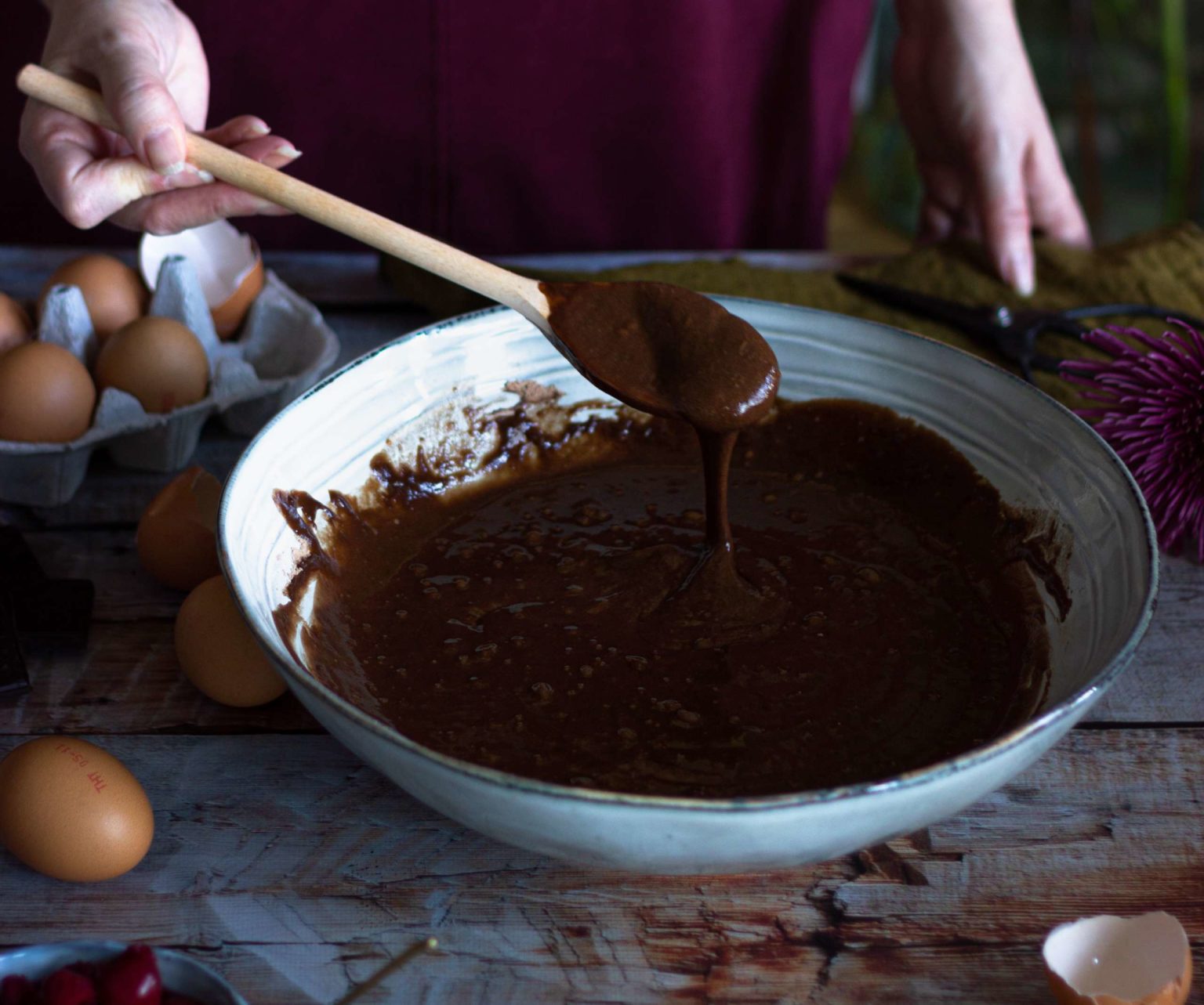 A bowl of melted chocolate with wooden spoon
