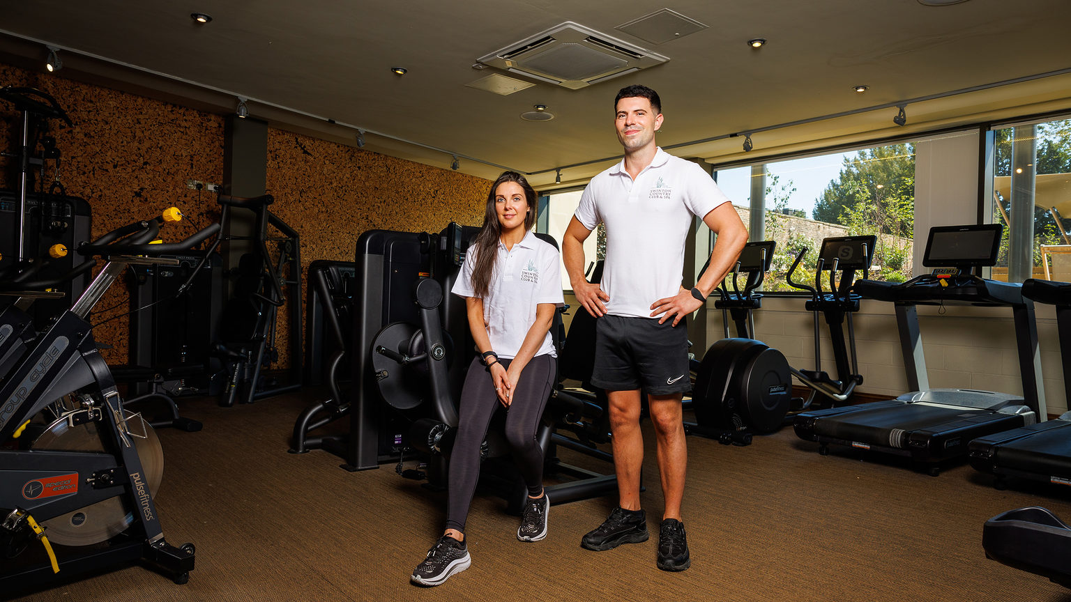 Two personal trainers posing in front of gym equipment at Swinton Country Club on the Swinton Estate in North Yorkshire