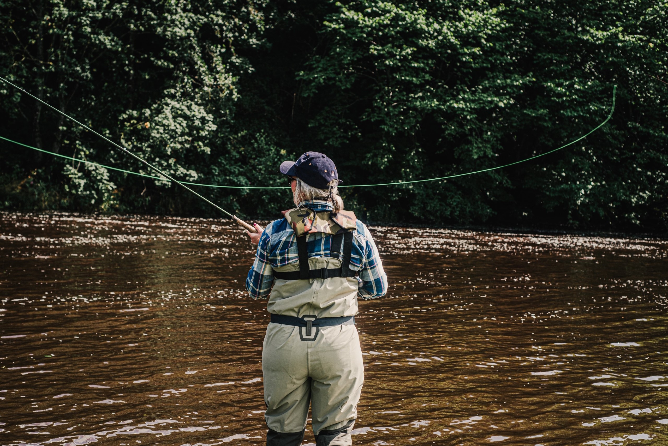 A woman fishing in a river in North Yorkshire