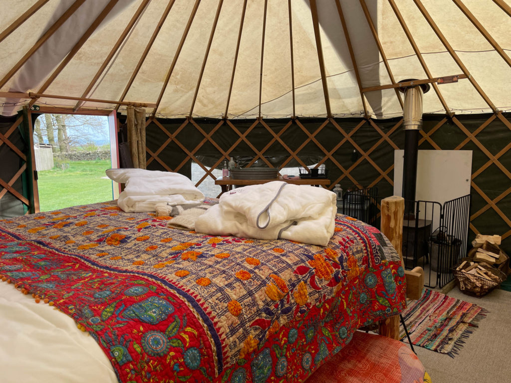 A glamping bed inside a luxury meadow yurt at Swinton Bivouac in North Yorkshire