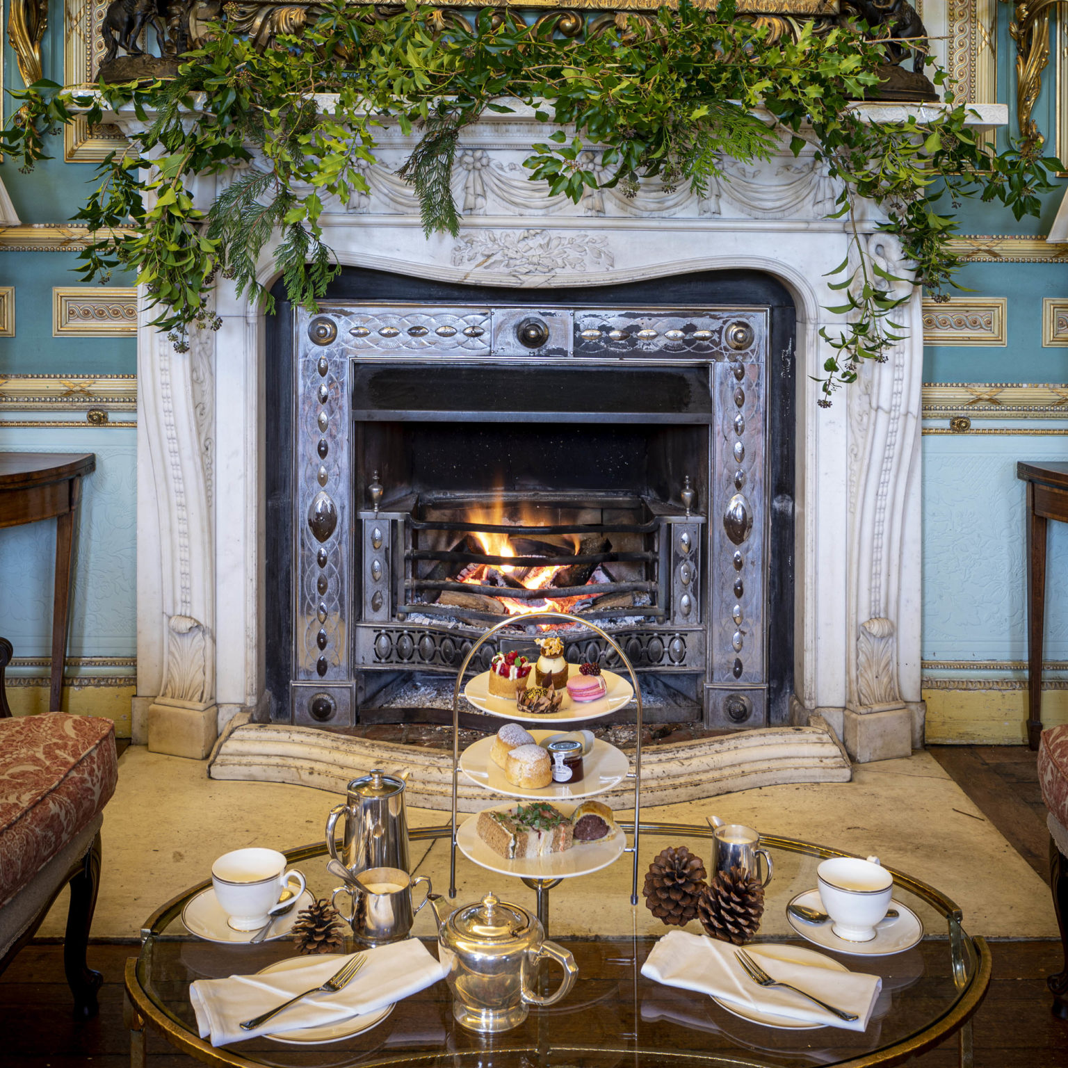 Afternoon tea on a coffee table in front of a fireplace at Swinton Park Hotel in North Yorkshire