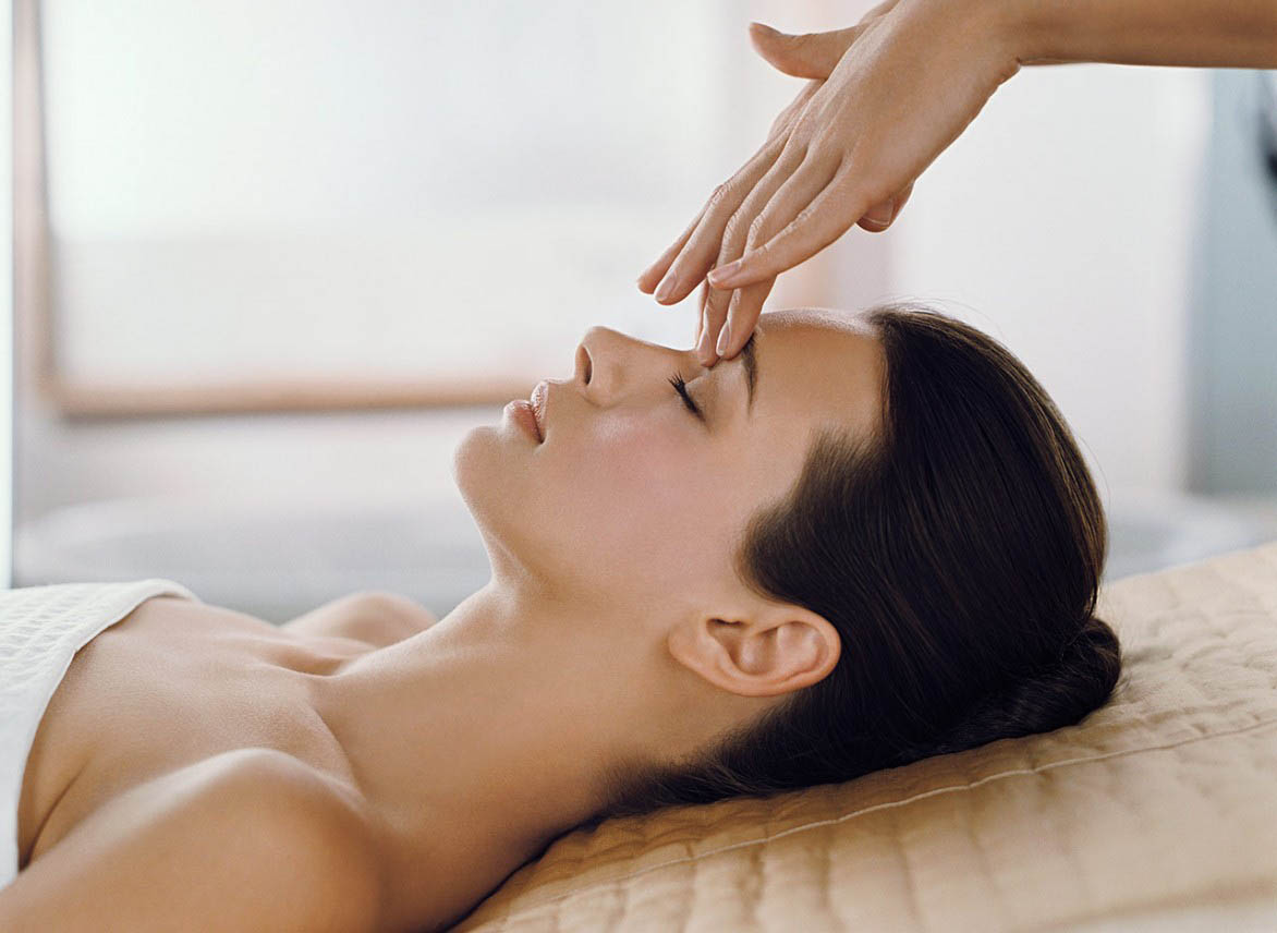 A woman receiving a face massage in a spa