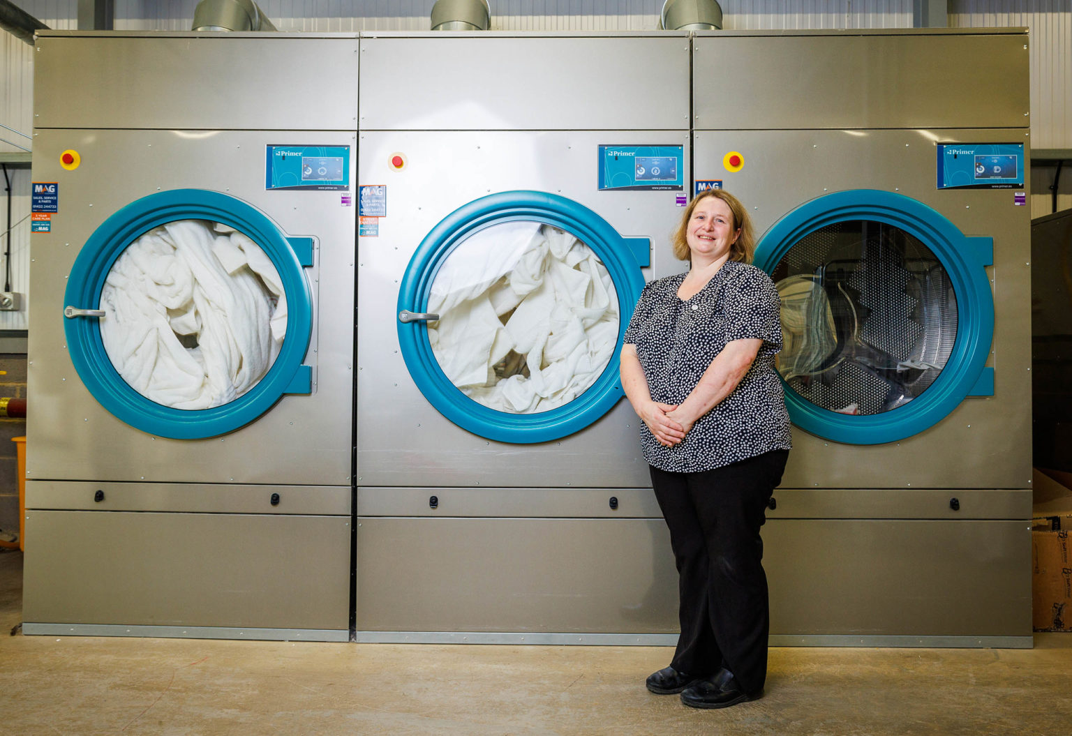 A woman standing in front of large industrial washing machines at Swinton Estate