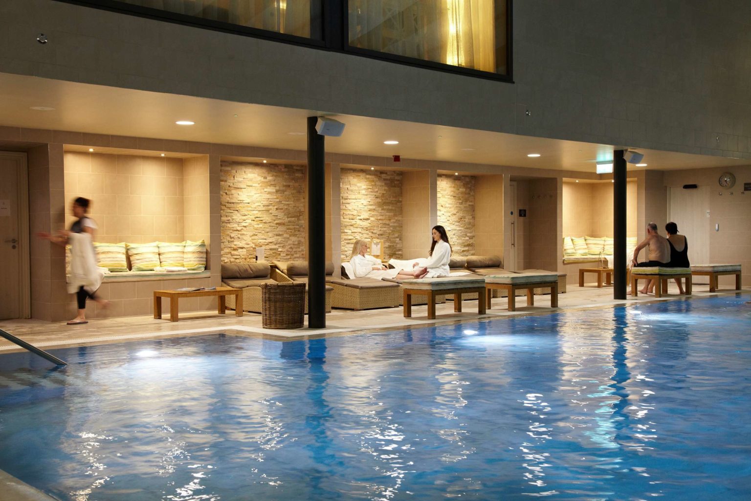 Guests relaxing next to the swimming pool during the evening at Swinton Country Club and Spa in North Yorkshire