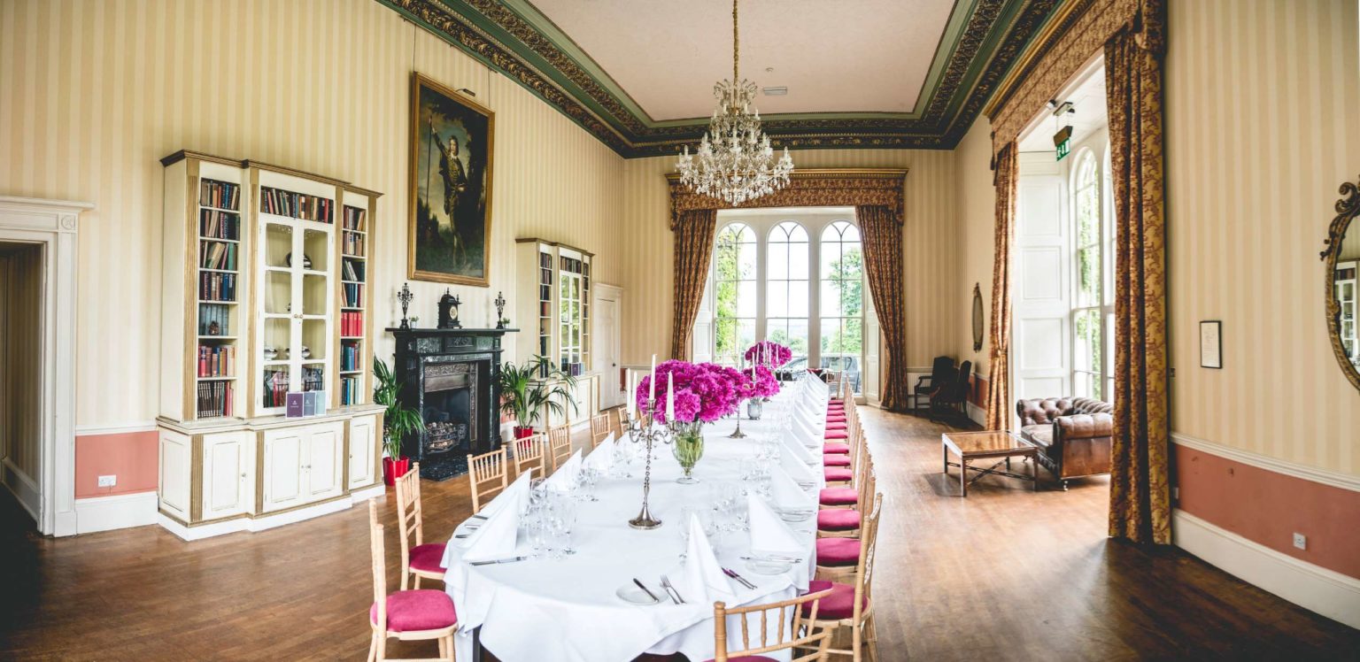 The Library room at Swinton Park Hotel set up with a long dining table ready for a meal