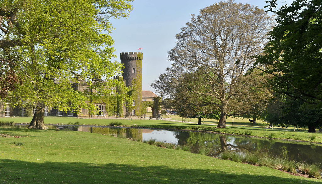 Swinton Park Hotel's castle turret as seen through trees from the Deer Park