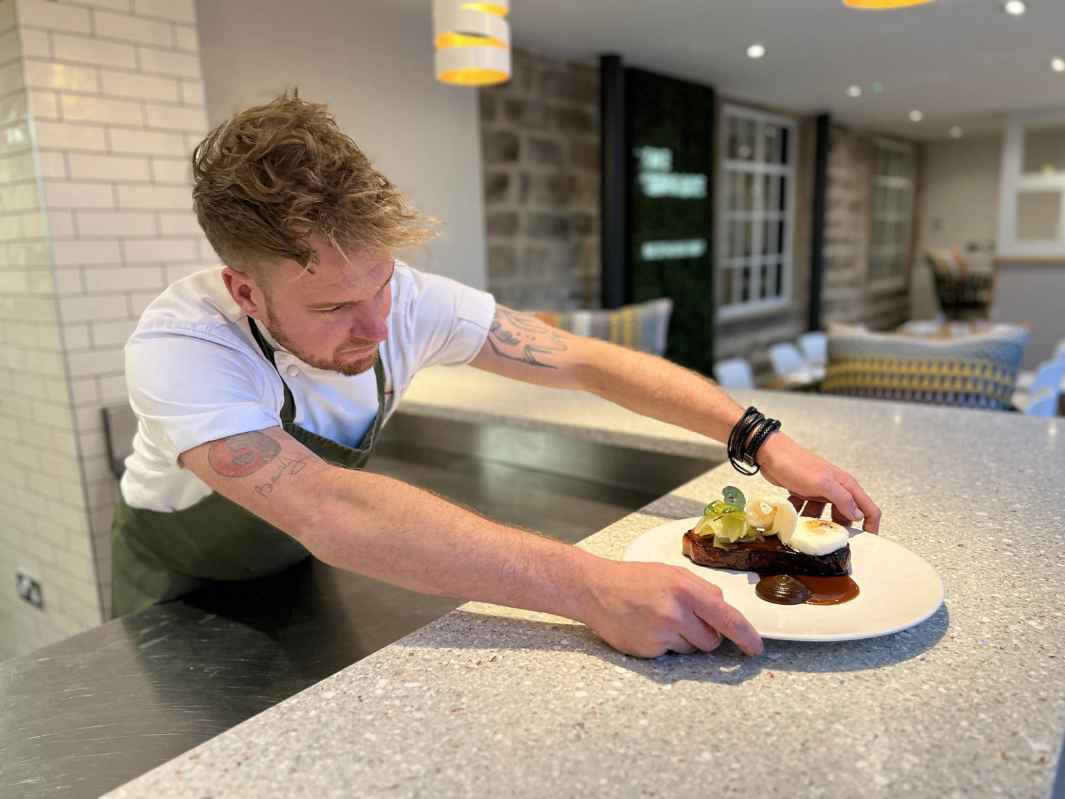 A chef serving a plate of food at The Terrace Restaurant and Bar on the Swinton Estate in North Yorkshire