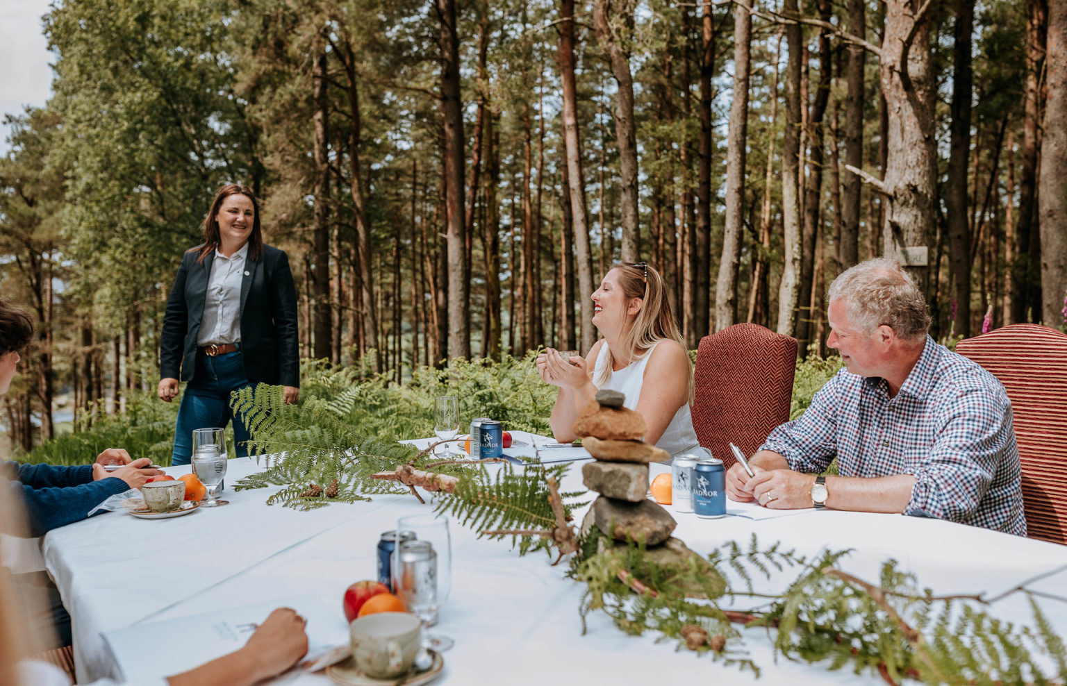 An outdoor business meeting taking place in a woodland on the Swinton Estate in North Yorkshire