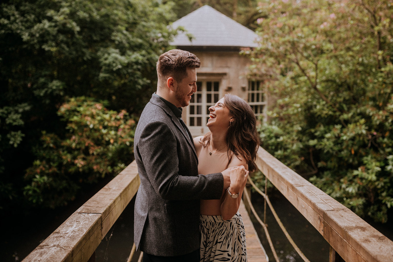 A happy couple embracing each other in front of the Lake House during a luxurious romantic wedding proposal at a venue in North Yorkshire. Photo by Peter Hugo.