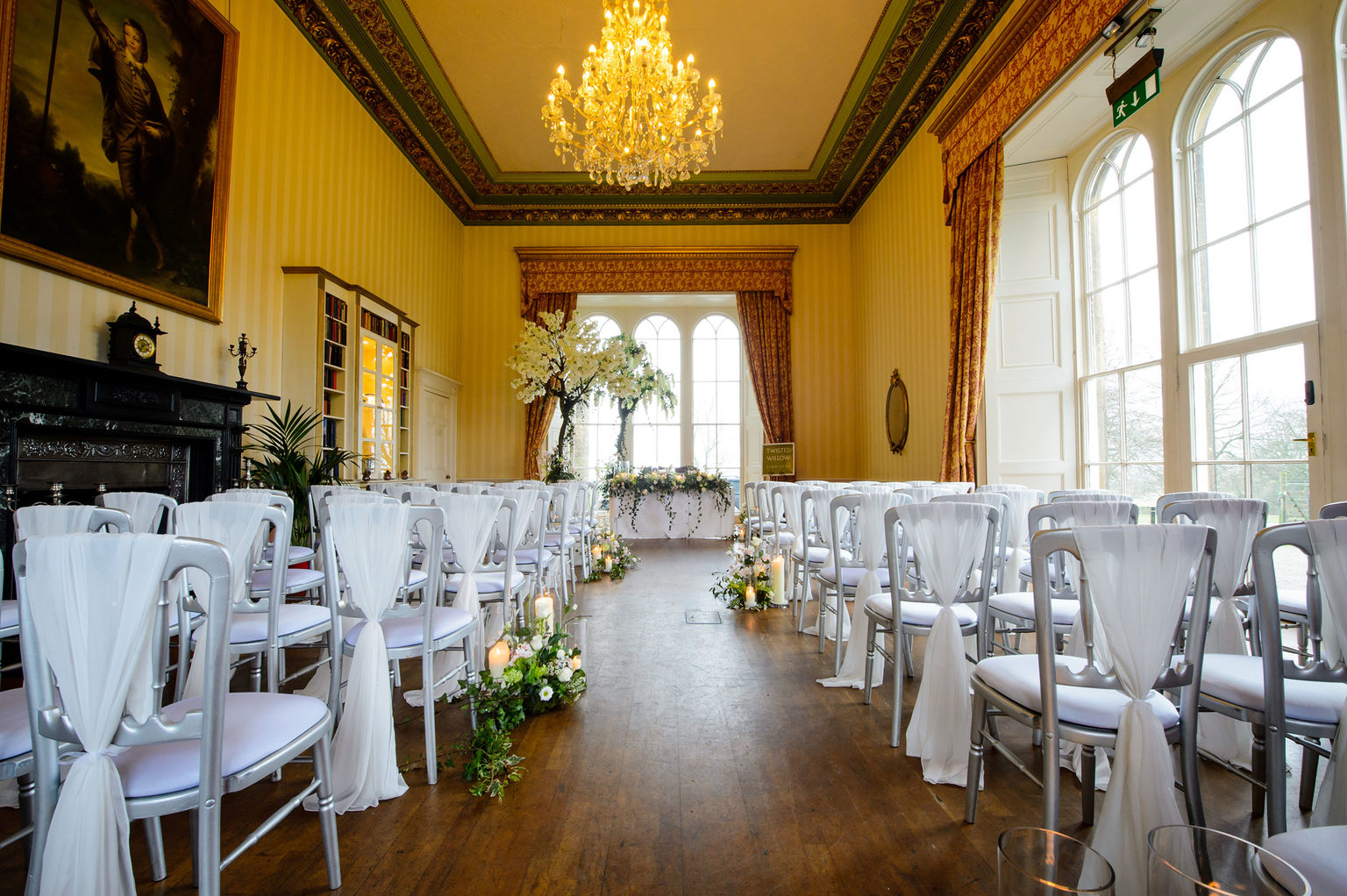 Rows of white chairs set up for a wedding ceremony in the Library at Swinton Estate in North Yorkshire.