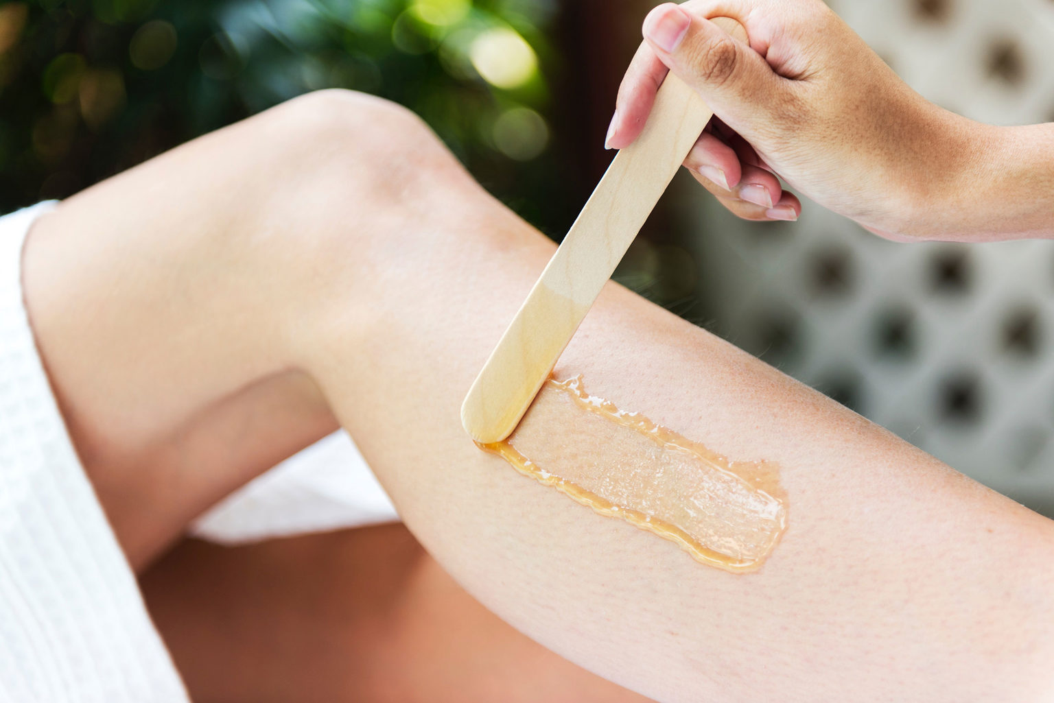 Applying wax to a leg during a spa beauty treatment