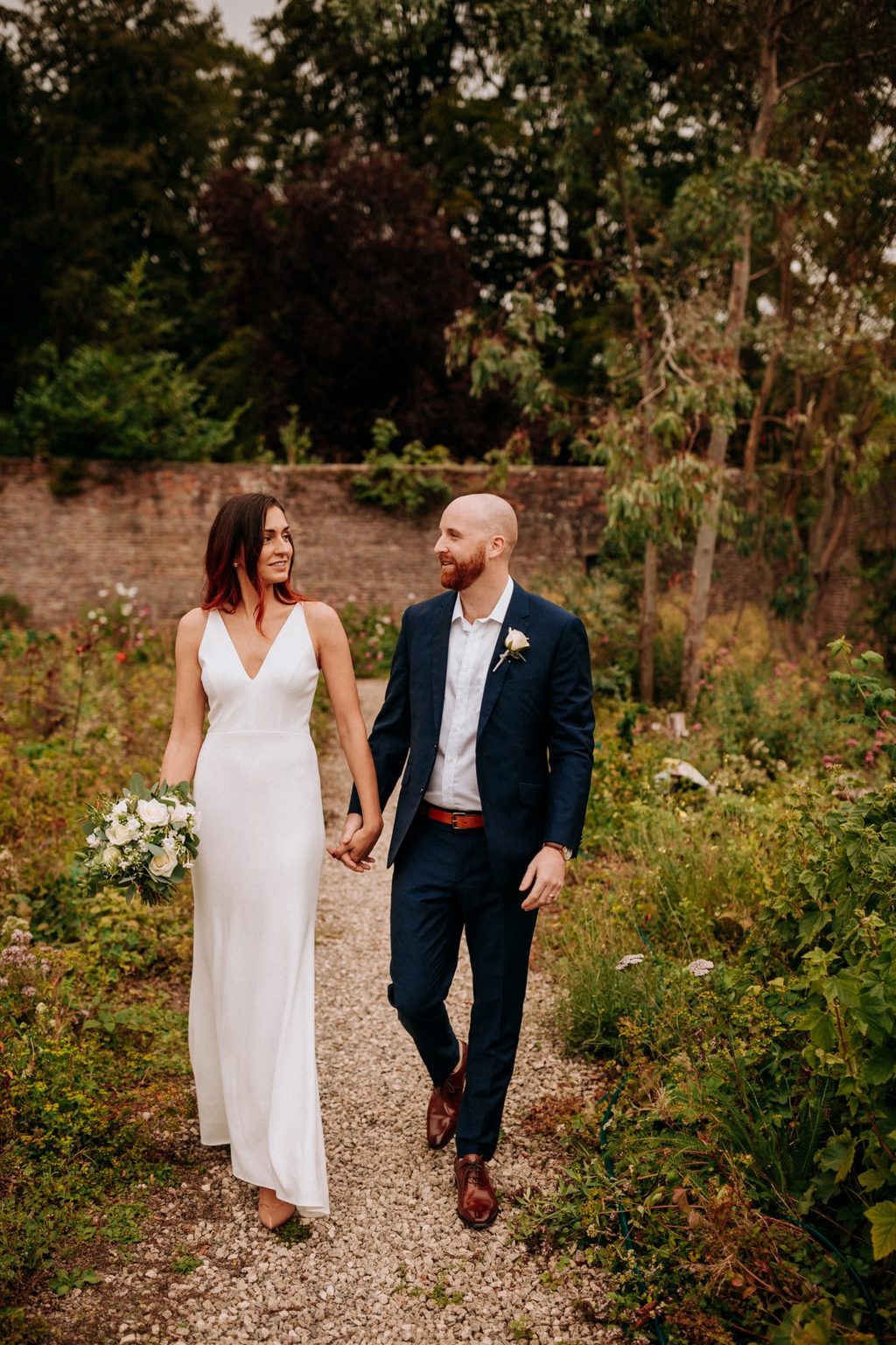 A couple walking in the garden during a castle wedding at Swinton Park Hotel in Yorkshire