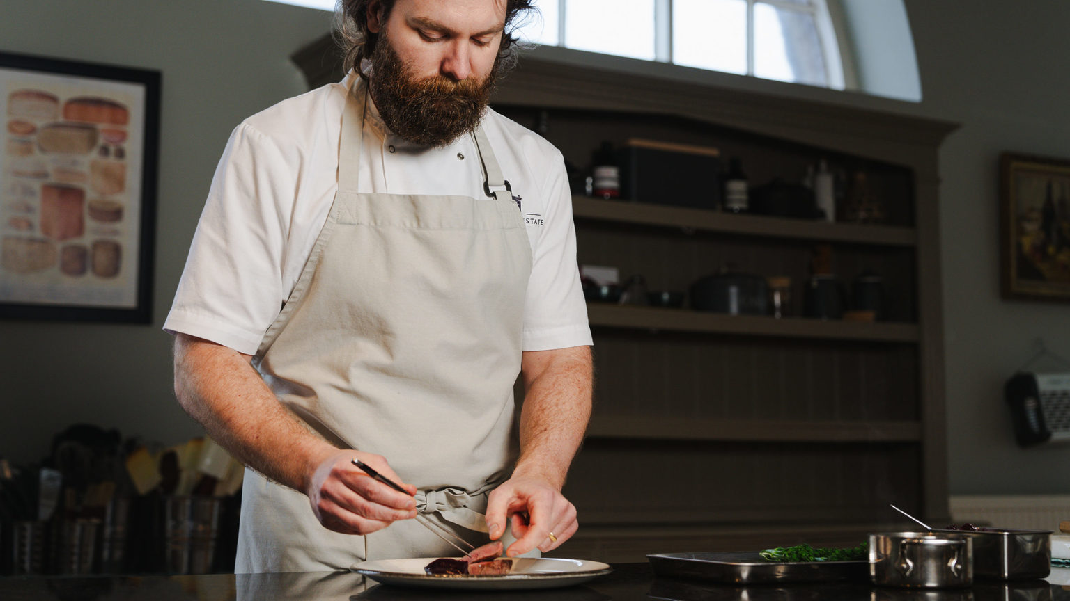 Chef Josh Barnes plating food as part of the Chef's Table on the Swinton Estate in North Yorkshire
